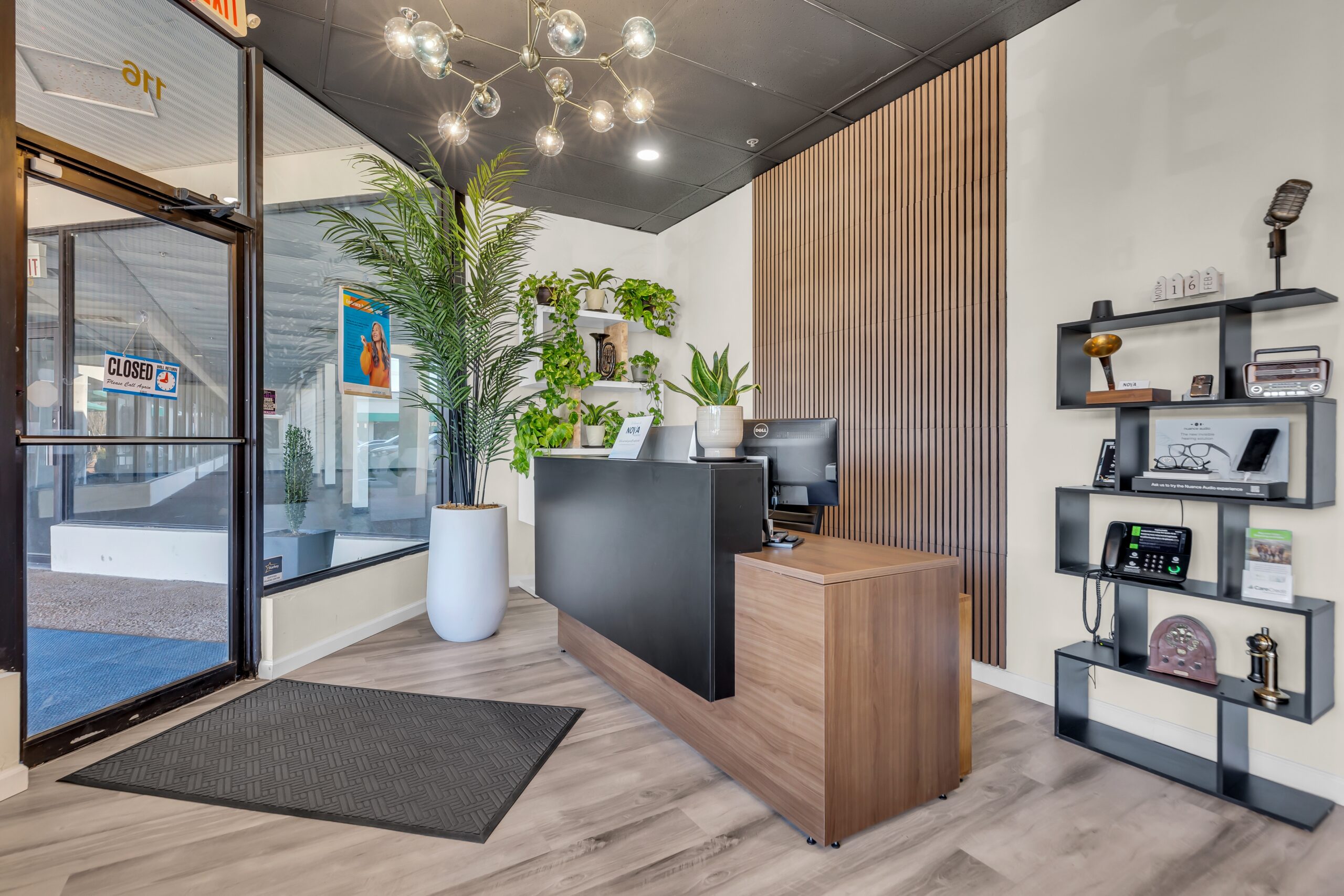 Modern reception desk with plants and shelving